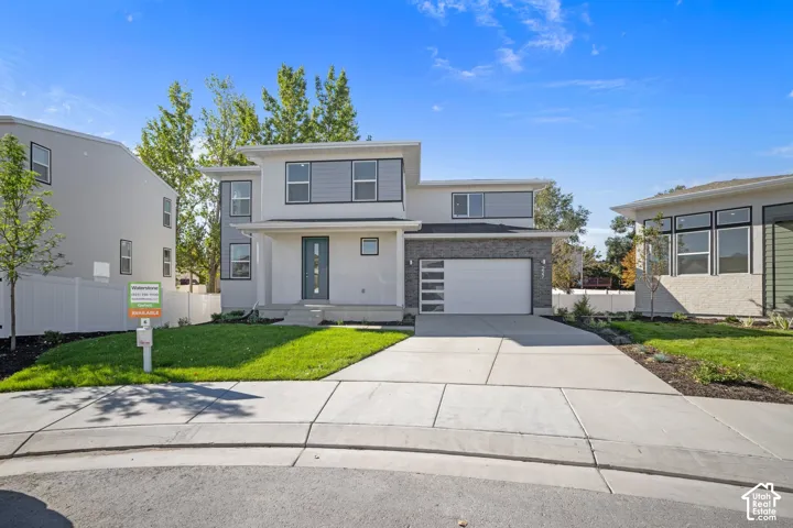 Two-story exterior featuring multi-textured facade, stone veneer accents, horizontal lap siding, a paneled garage door with glass inserts, and a concrete driveway