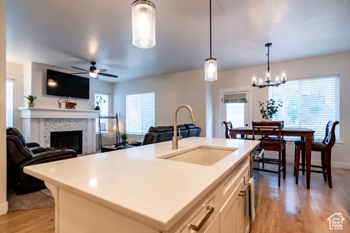 Open-concept living space featuring a kitchen island with an undermount sink and a gooseneck faucet