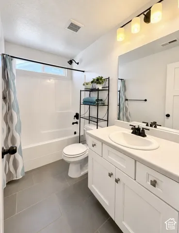 Bathroom featuring a white vanity with an integrated sink, matte black faucet, and a large mirror