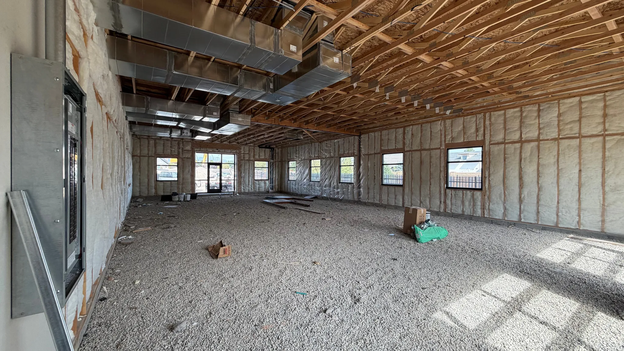 Exposed wood ceiling joists, multiple windows, and extensive wall insulation define this spacious interior