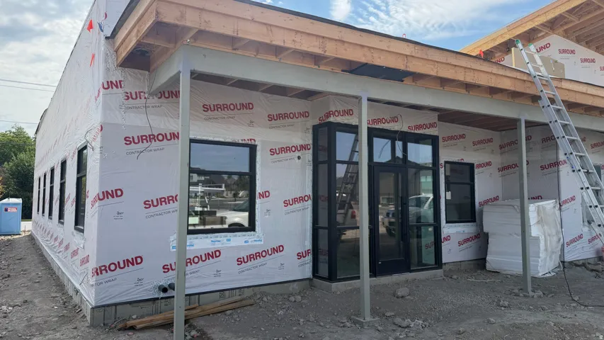 New construction with a prominent entry, multiple windows, and an overhang structure