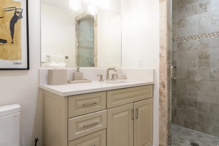 Bathroom featuring a single vanity with stone-finish countertop, brushed nickel faucet, and integrated sink