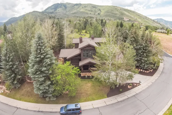 Multi-level residence featuring a dark wood exterior, a multi-peak roofline, and prominent chimney structures