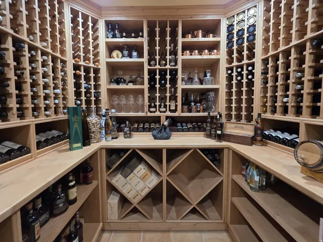 Custom built-in wood wine racks, perimeter wood countertops, and integrated display shelving