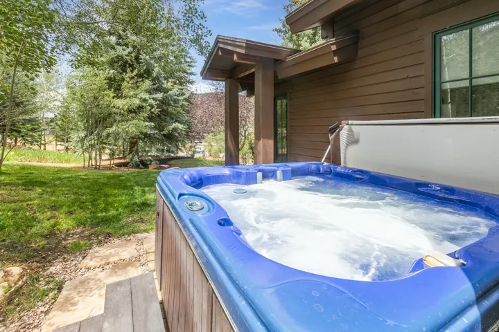 Outdoor hot tub with blue interior and wood-finish exterior paneling