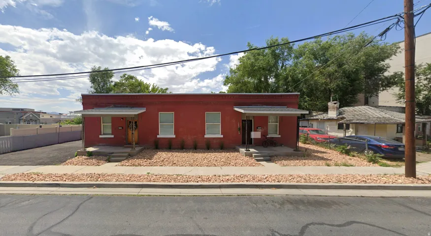 Red brick exterior featuring multiple windows and two covered entryways