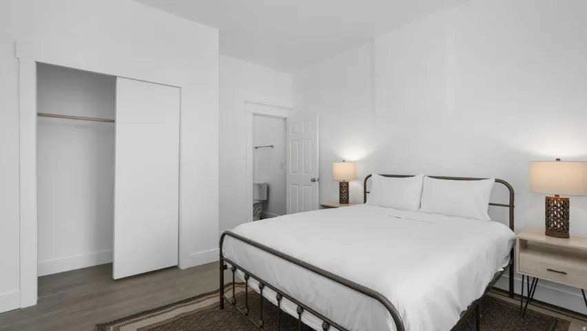 Bedroom with wood-finish flooring and a white sliding closet door
