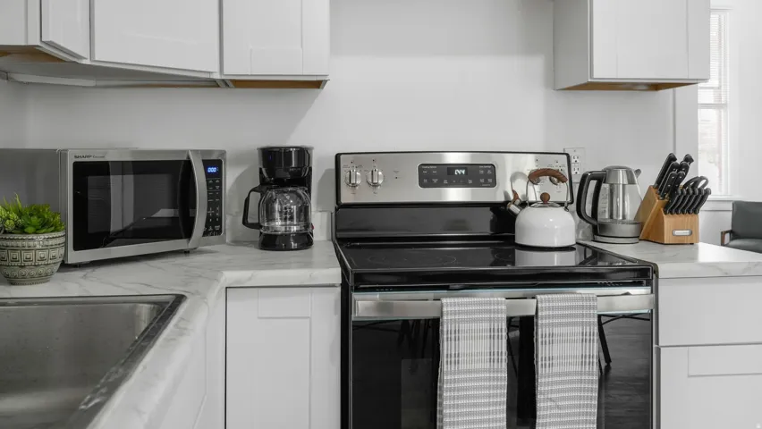 Kitchen area featuring white cabinetry, light-toned countertops, and a stainless steel range with a black cooktop