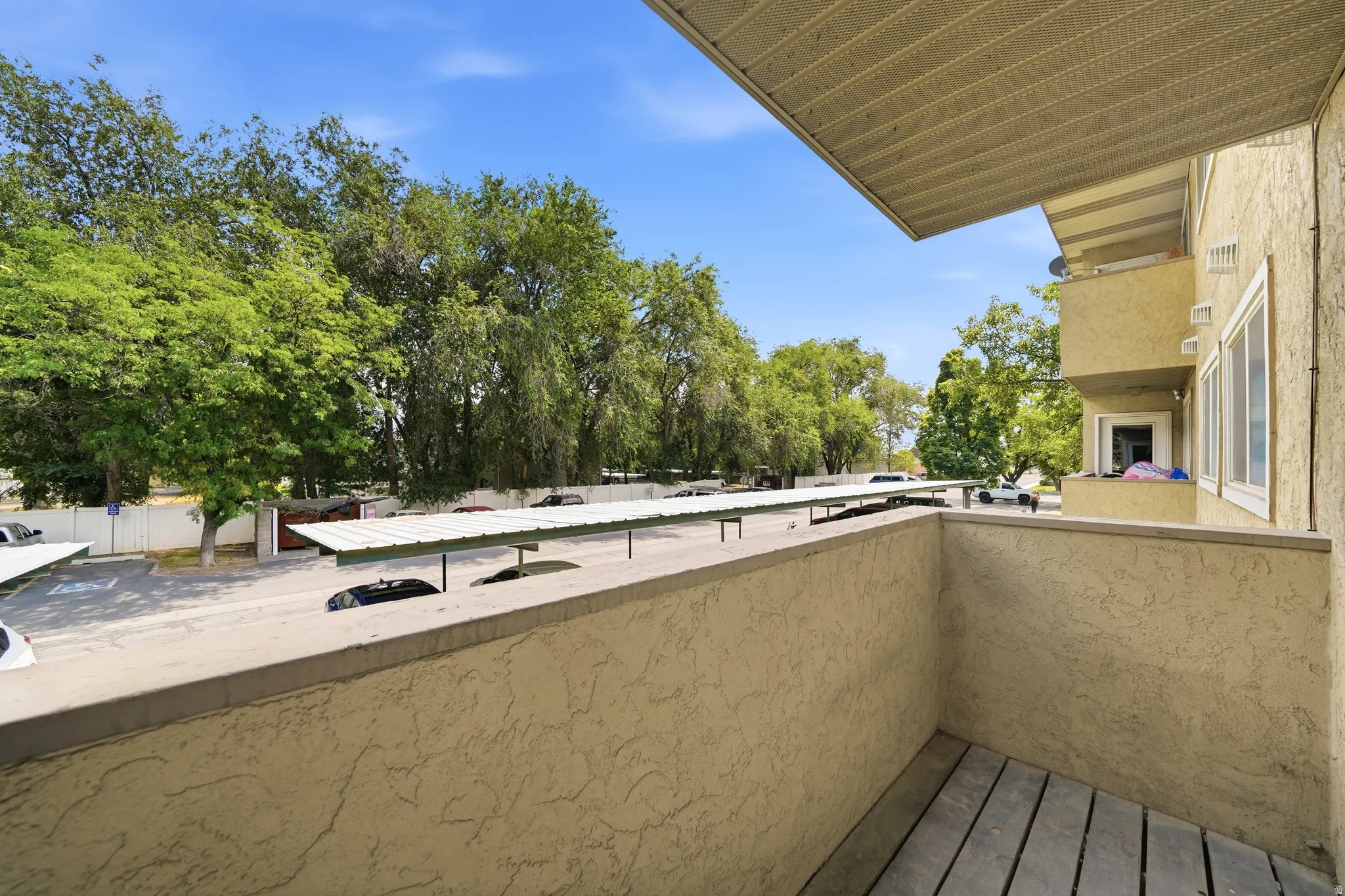 Private balcony featuring wood-finish flooring and stucco walls