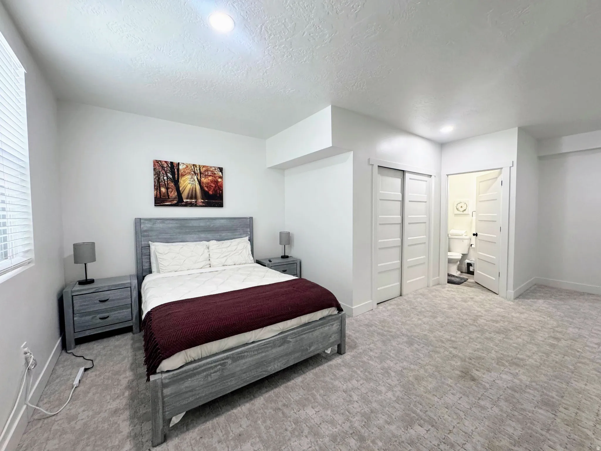Carpeted room with white walls, recessed lighting, a window with blinds, and white bi-fold closet doors
