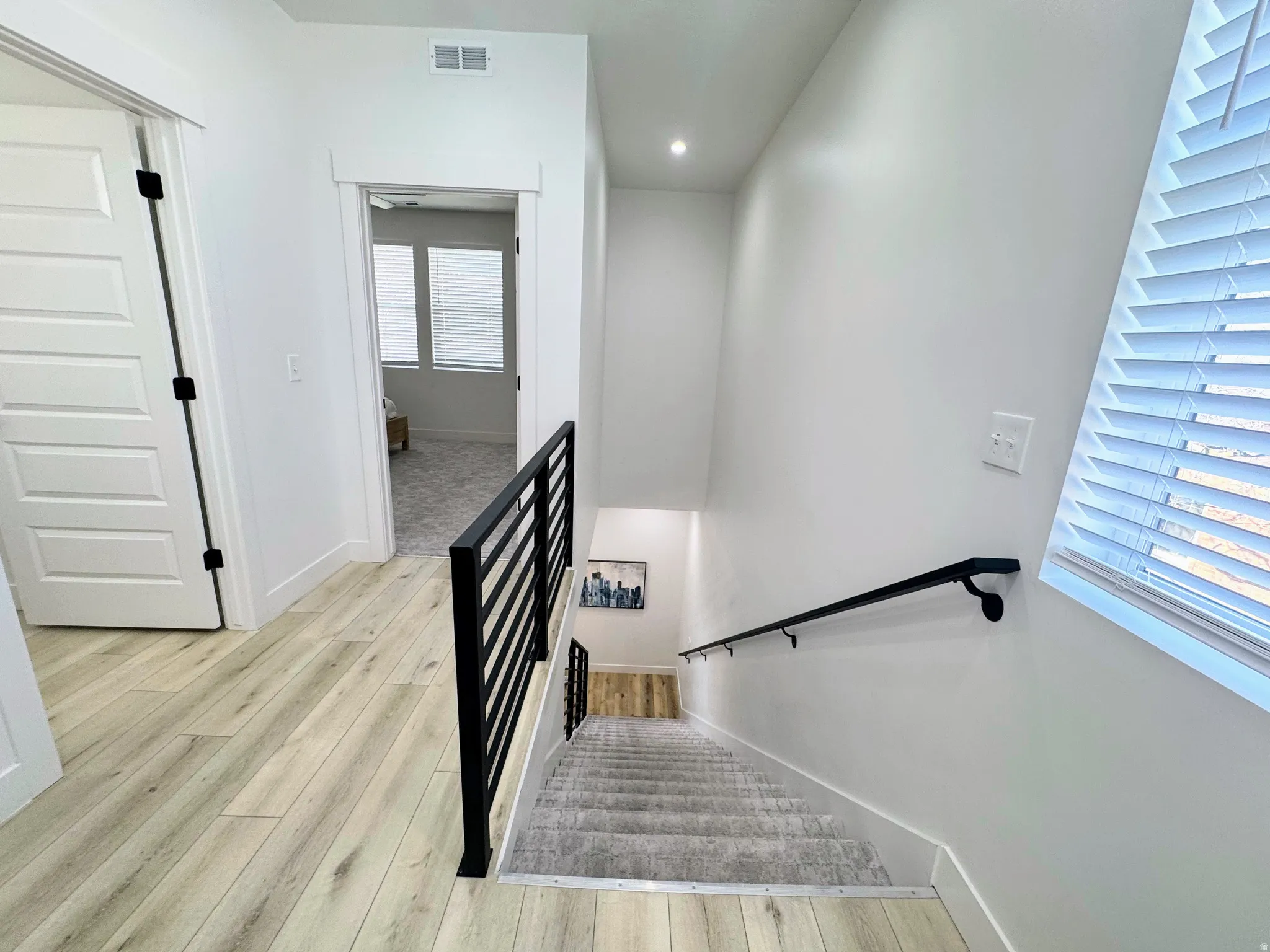 Hallway featuring wood-finish flooring, white walls, and a recessed ceiling light