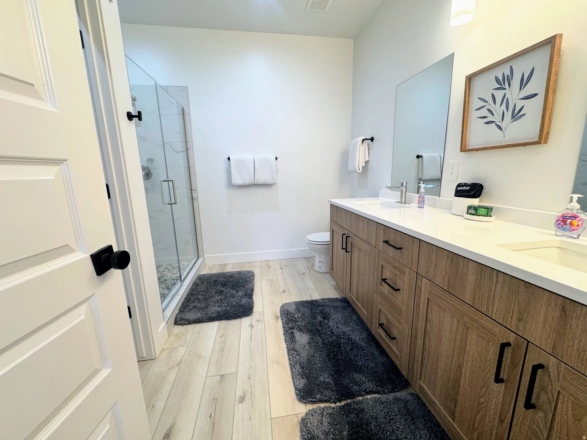 Light wood-finish flooring complements the spacious bathroom