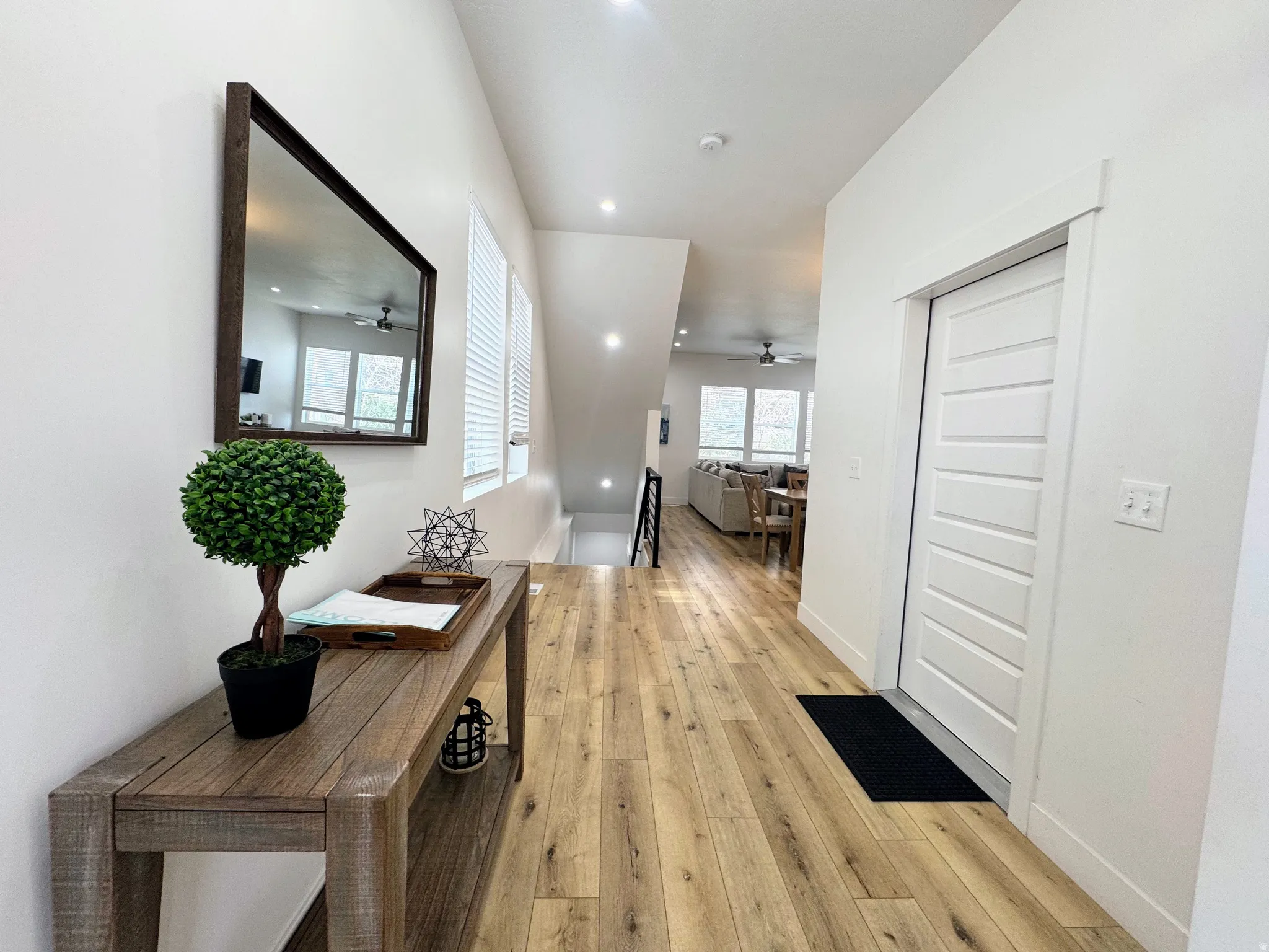 Entryway featuring wood-finish flooring, recessed lighting, and a contemporary paneled interior door