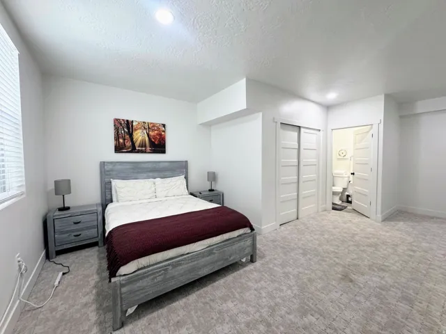 Carpeted room with white walls, recessed lighting, a window with blinds, and white bi-fold closet doors