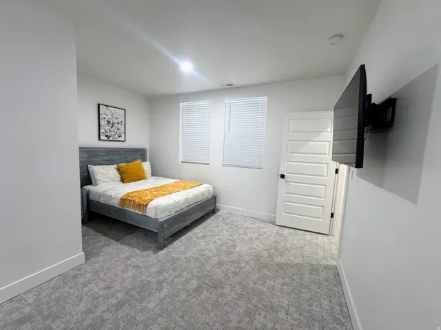 Room featuring patterned carpet flooring, white walls, and a multi-panel interior door with black hardware