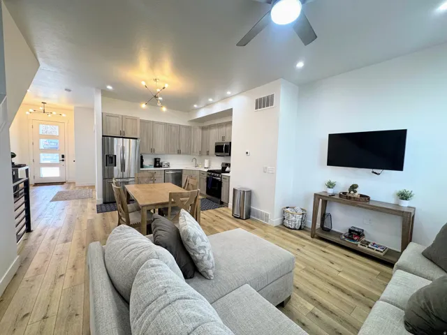 Open-concept living area featuring wood-finish flooring, recessed lighting, and a ceiling fan