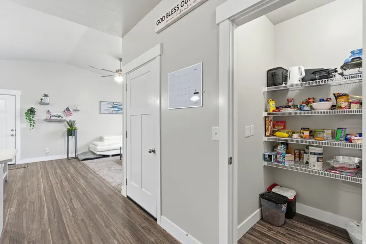 Pantry with wire shelving, wood-finish flooring, and white trim