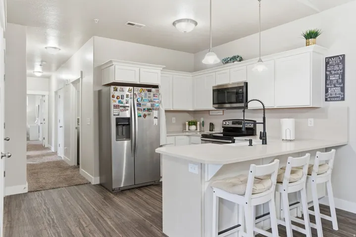 Modern kitchen featuring white cabinetry, light-toned countertops, and a stainless steel appliance suite