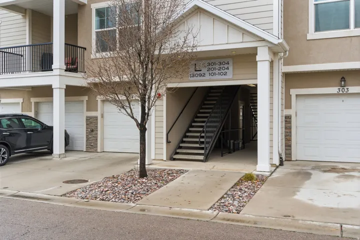 Multi-story building exterior with beige siding and stone accents