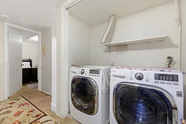 Dedicated laundry area with white walls and a built-in shelf