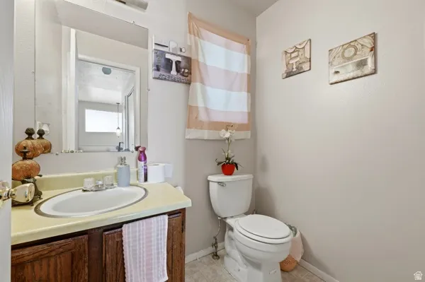 Bathroom featuring a vanity with dark wood-finish cabinetry, a light-toned countertop, and an oval undermount sink