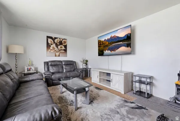 Bright living space featuring light-colored walls and a wall-mounted television