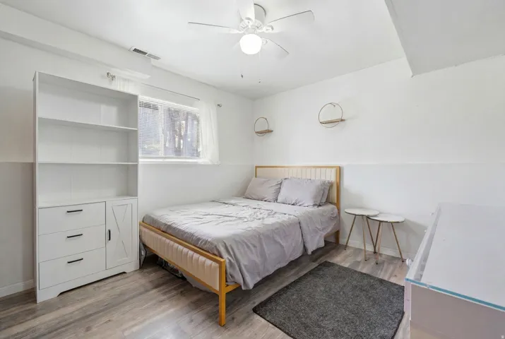 Bright room featuring wood-finish flooring and a white built-in storage unit with drawers and a cabinet