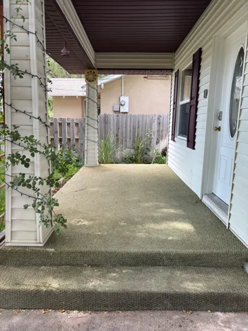 Covered front porch with textured green outdoor carpeting