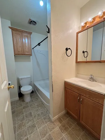 Bathroom featuring a vanity with wood-finish cabinetry, a white countertop, and an integrated sink