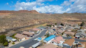 Residential neighborhood featuring paved streets and varied rooflines, set against a desert landscape with distant mountains
