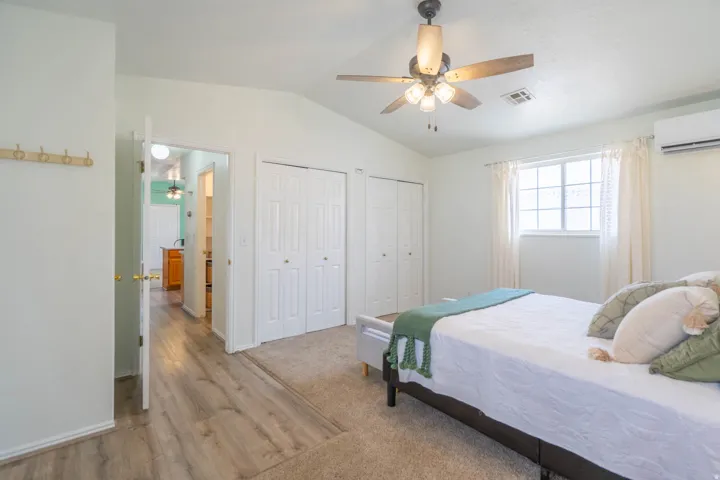 Interior room featuring a vaulted ceiling and a ceiling fan with integrated lighting