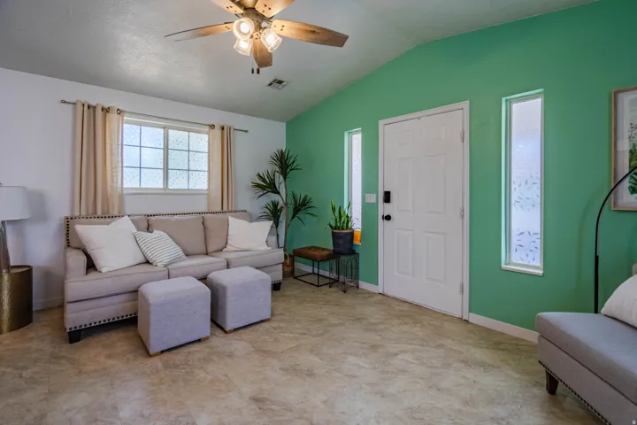 Vaulted ceiling in the living area featuring a ceiling fan with integrated lighting