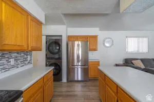 Kitchen area with light wood-finish cabinetry, light countertops, and a mosaic tile backsplash