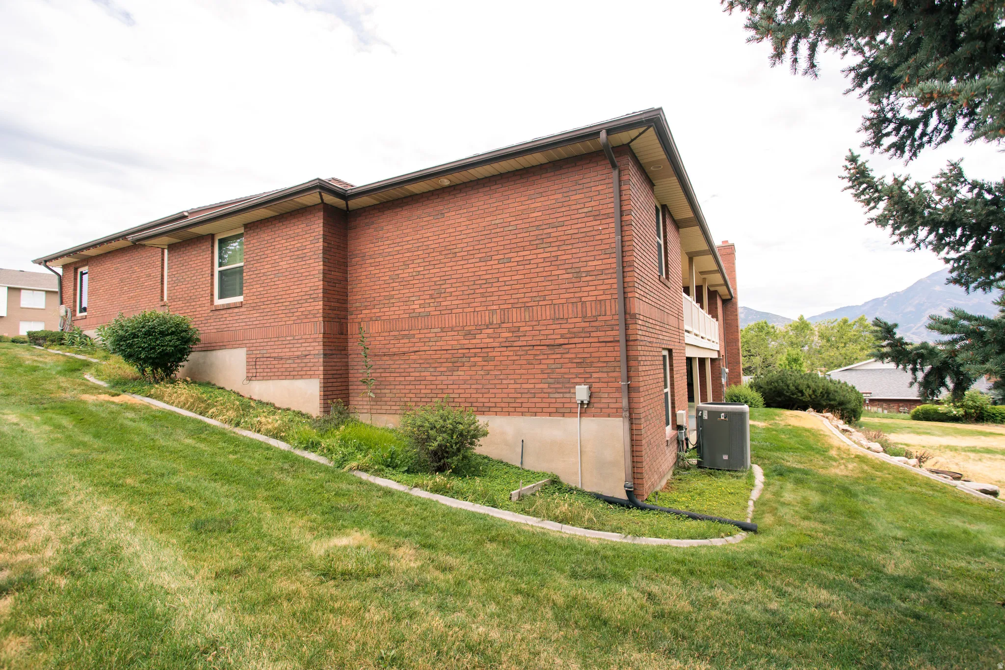 Brick exterior with a partial lower-level foundation and a balcony