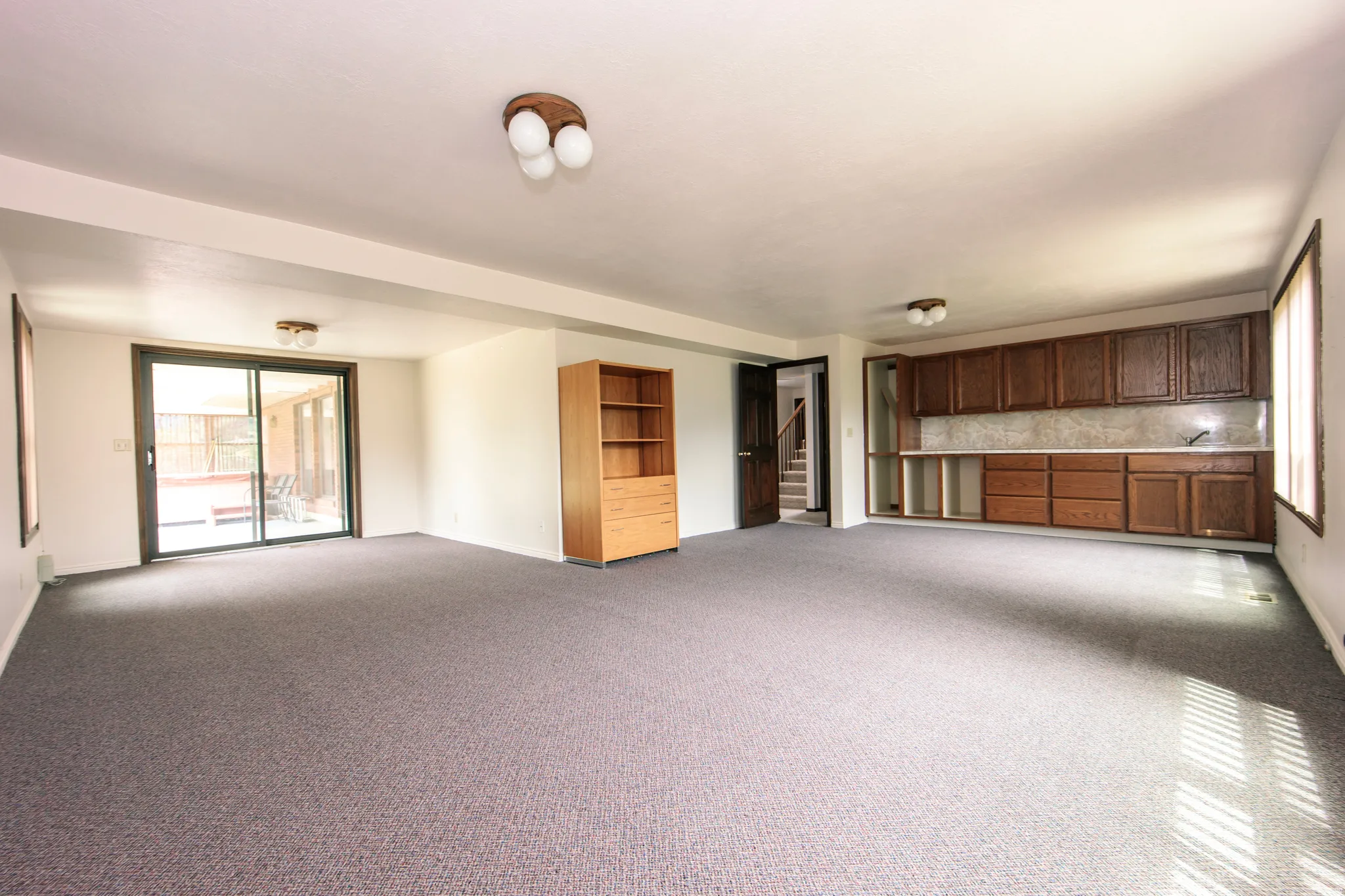 Spacious room featuring gray carpeting and white walls