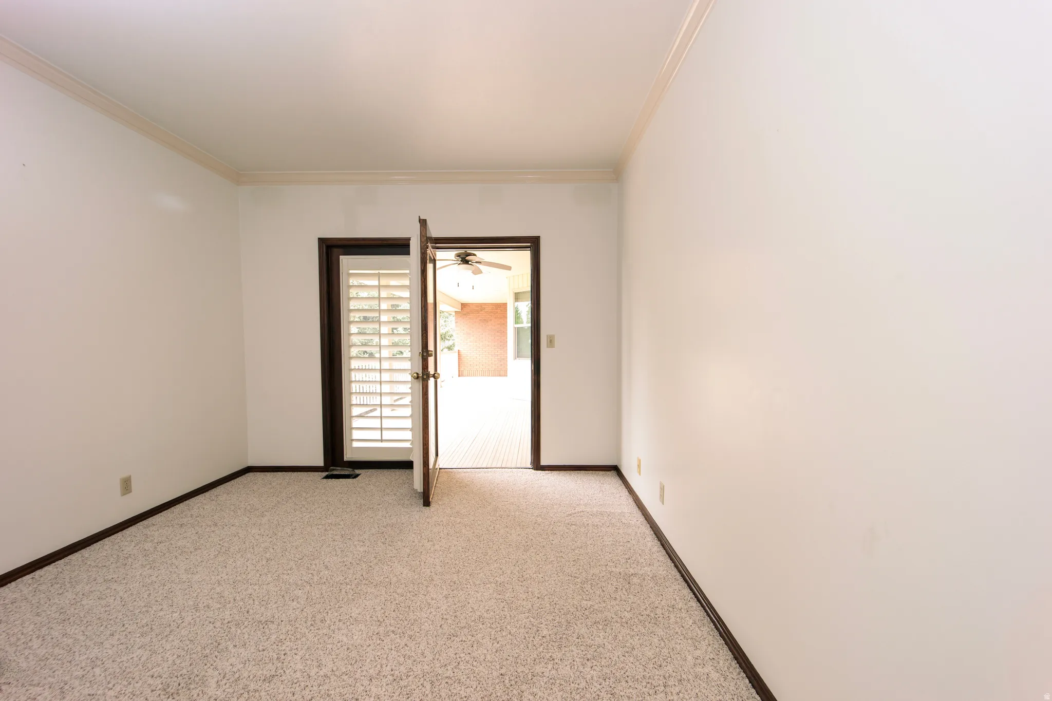 Room featuring light-toned carpet flooring, white walls, and dark baseboards