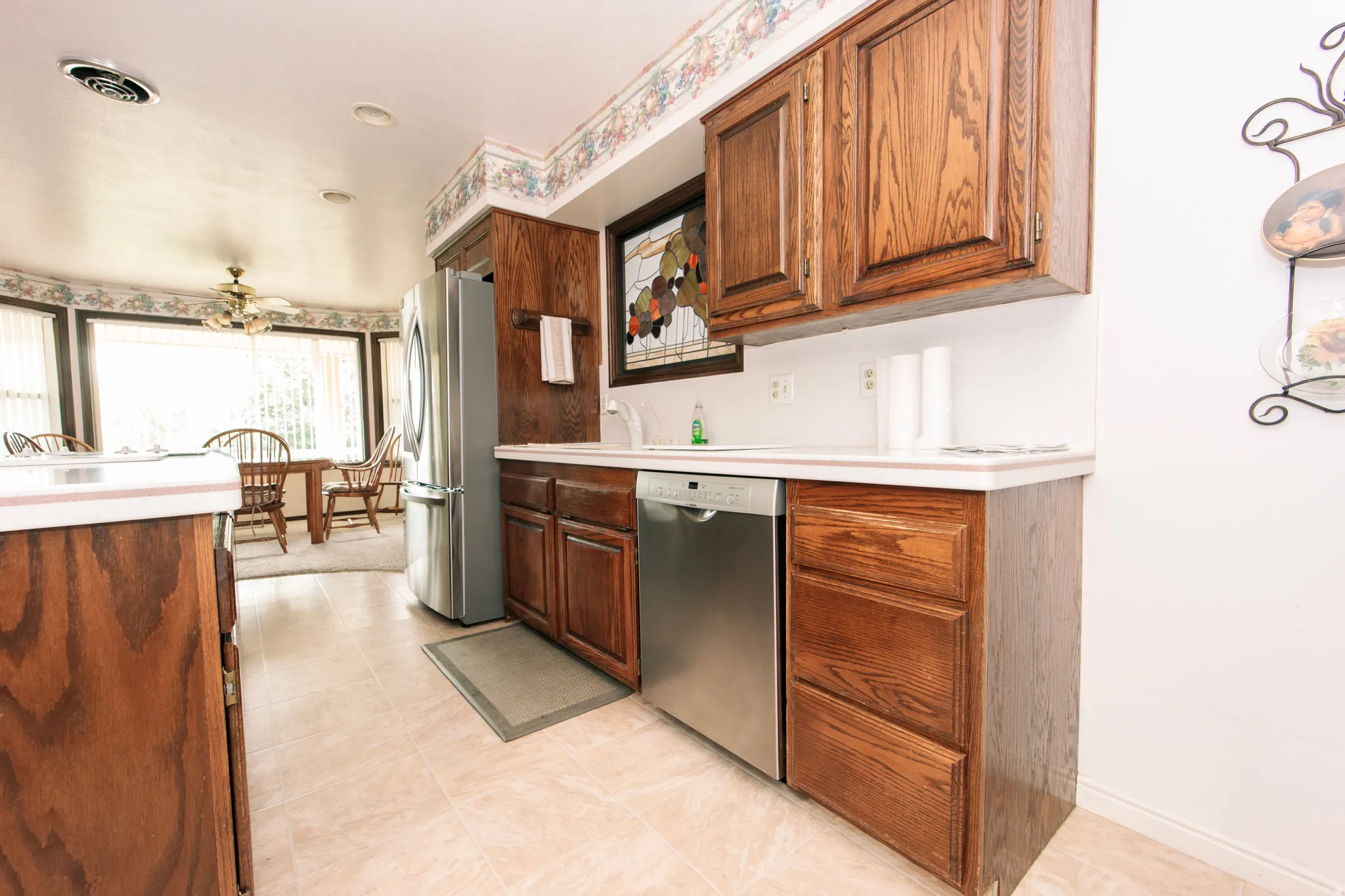 Kitchen featuring wood cabinetry, stainless steel appliances, and a tiled floor