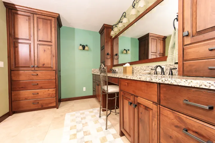 Bathroom vanity featuring double sinks with granite countertops and dark bronze hardware