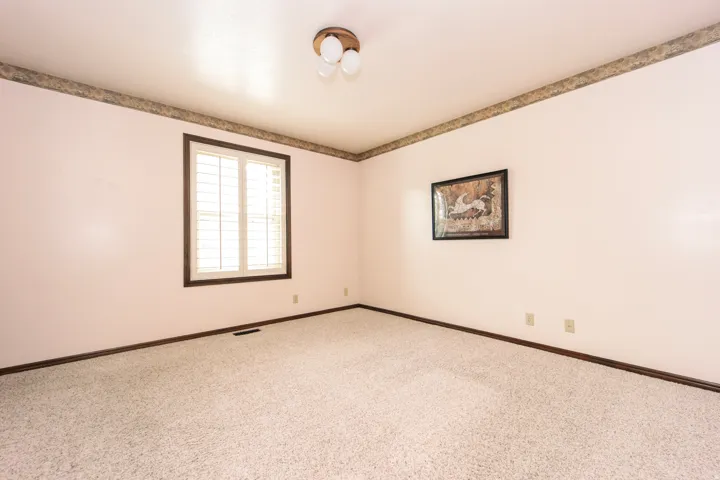 Room featuring carpet flooring and light-toned walls with a decorative border