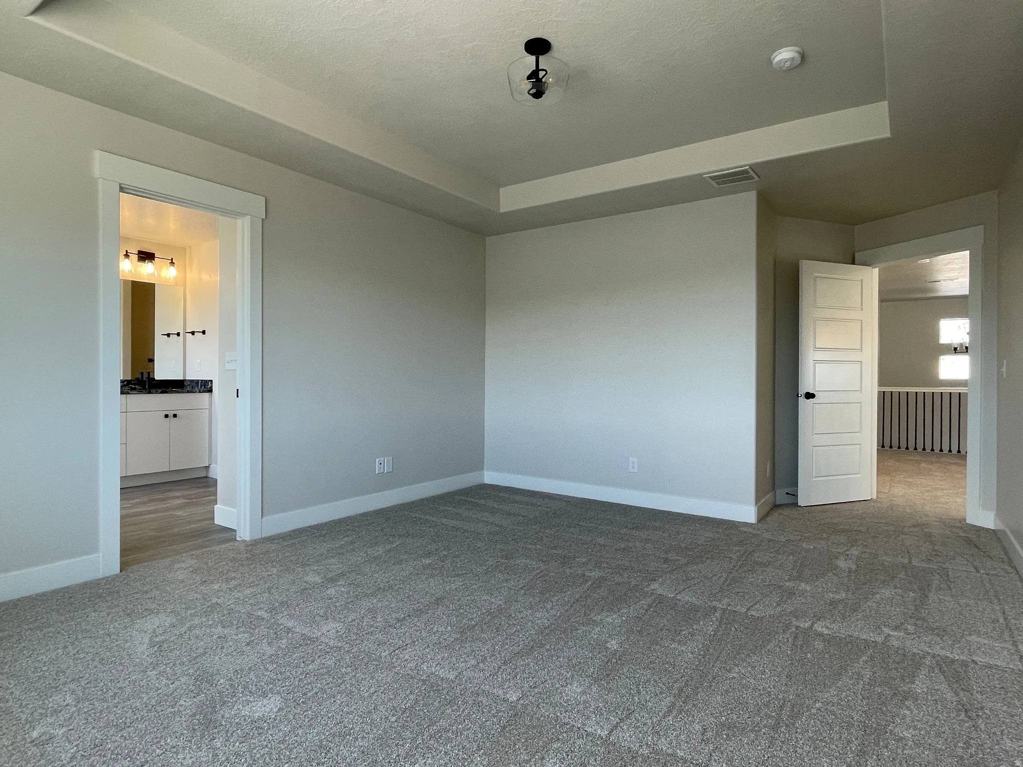 Spacious room featuring neutral carpeting and light gray walls