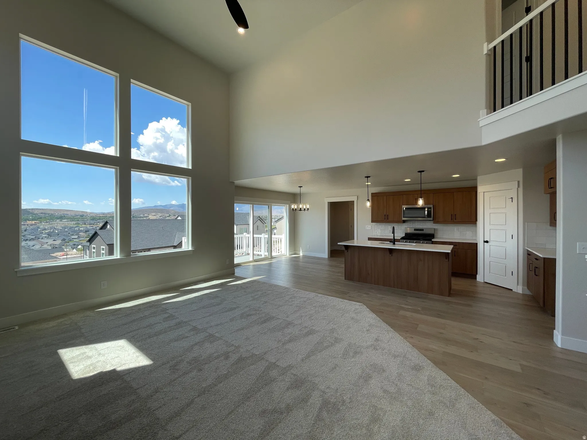 Two-story living area featuring a vaulted ceiling and large picture windows