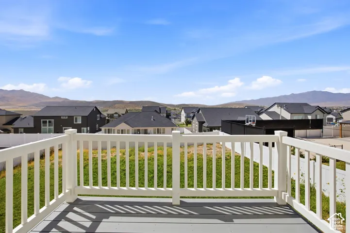 Deck with white railing and gray composite decking overlooking a graded lot