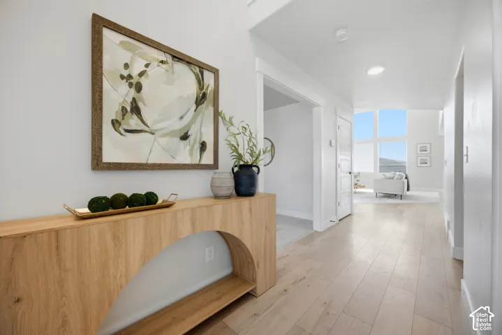 Wide plank wood-finish flooring, recessed lighting, and a white color palette