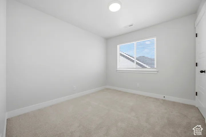 Light-colored carpeted flooring, window with blinds, white trim, recessed lighting, and a paneled door