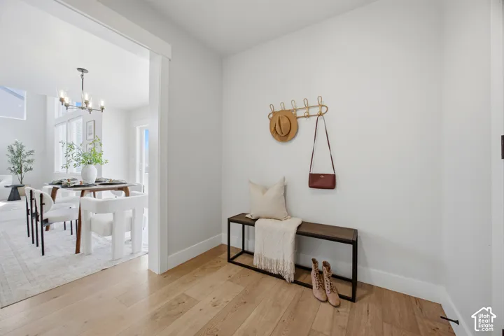 Wide plank wood-finish flooring, recessed lighting, and a modern chandelier