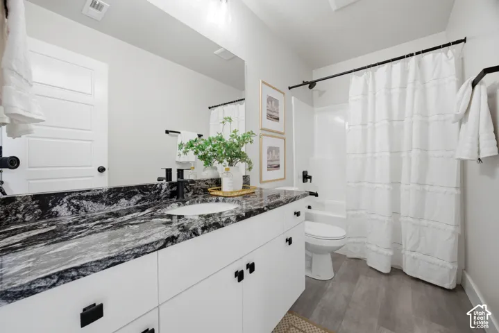 Vanity with black-patterned countertop, integrated sink, and black fixtures