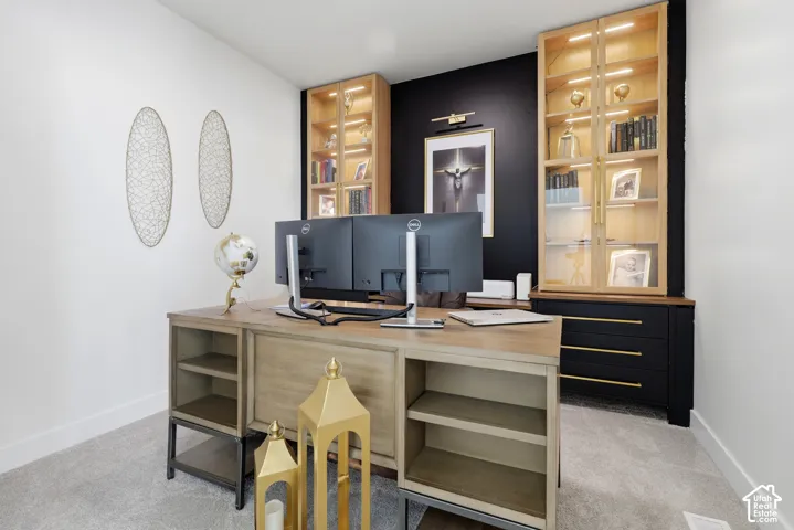 Built-in cabinetry with glass-front doors, integrated lighting, and dark lower storage with gold-tone hardware