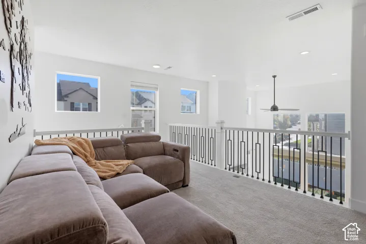 Spacious loft-style room featuring expansive windows with cityscape vistas, polished concrete flooring, recessed ceiling lighting, and a modern white metal railing system