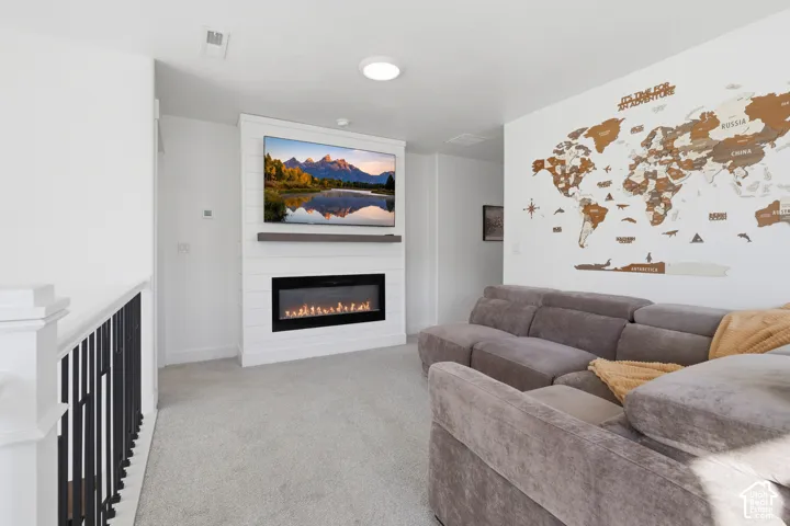 Shiplap accent wall featuring an electric fireplace and mounted television