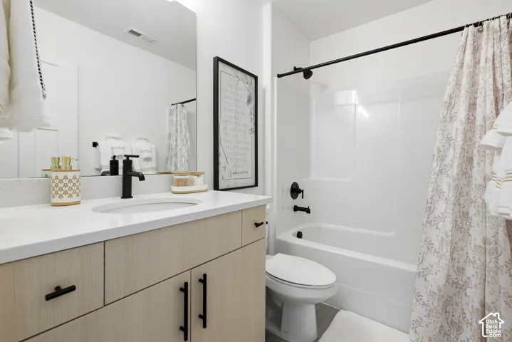 Contemporary vanity with light wood-finish cabinetry, white countertop, and matte black fixtures